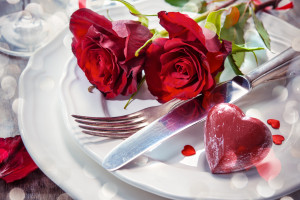 Festlich gedeckter Tisch beim Catering mit roten Rosen und Herz